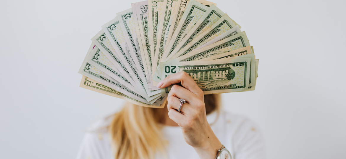 A woman holding up a fan of money