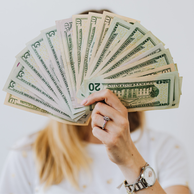 A woman holding up a fan of money