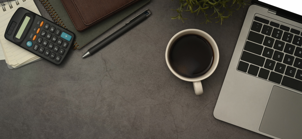 Coffee, calculator and laptop on desk