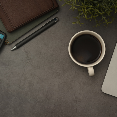 Coffee, calculator and laptop on desk