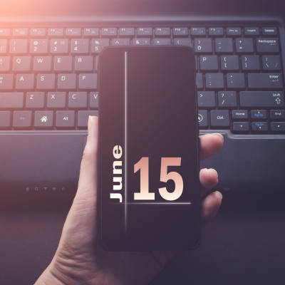 phone screen showing June 15 over a laptop.