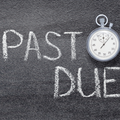 The words past due in chalk next to a stopwatch